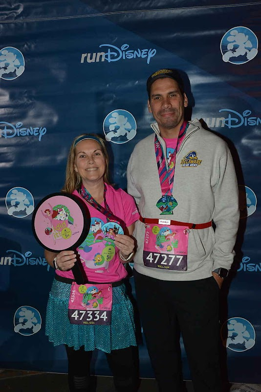 Melissa and her husband in matching runDisney race outfits at the Princess Half Marathon Weekend