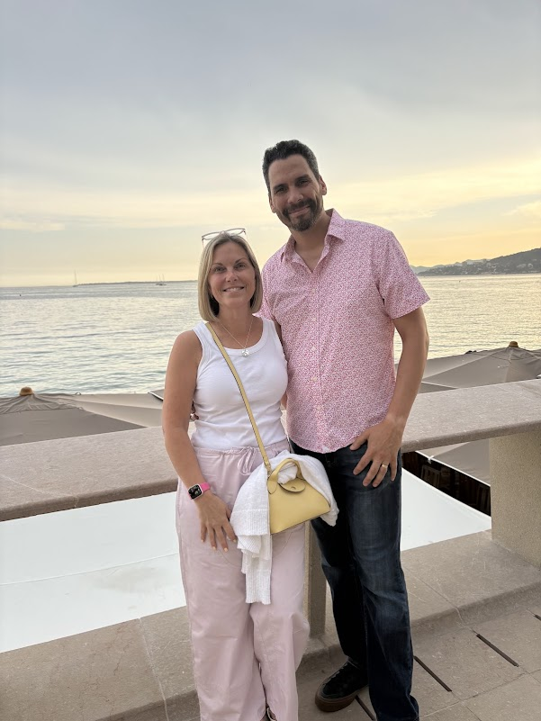 Couple enjoying a seaside sunset on an empty-nester getaway