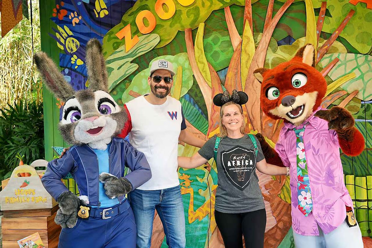 Melissa and her husband posing with Judy Hopps and Nick Wilde at a Disney park